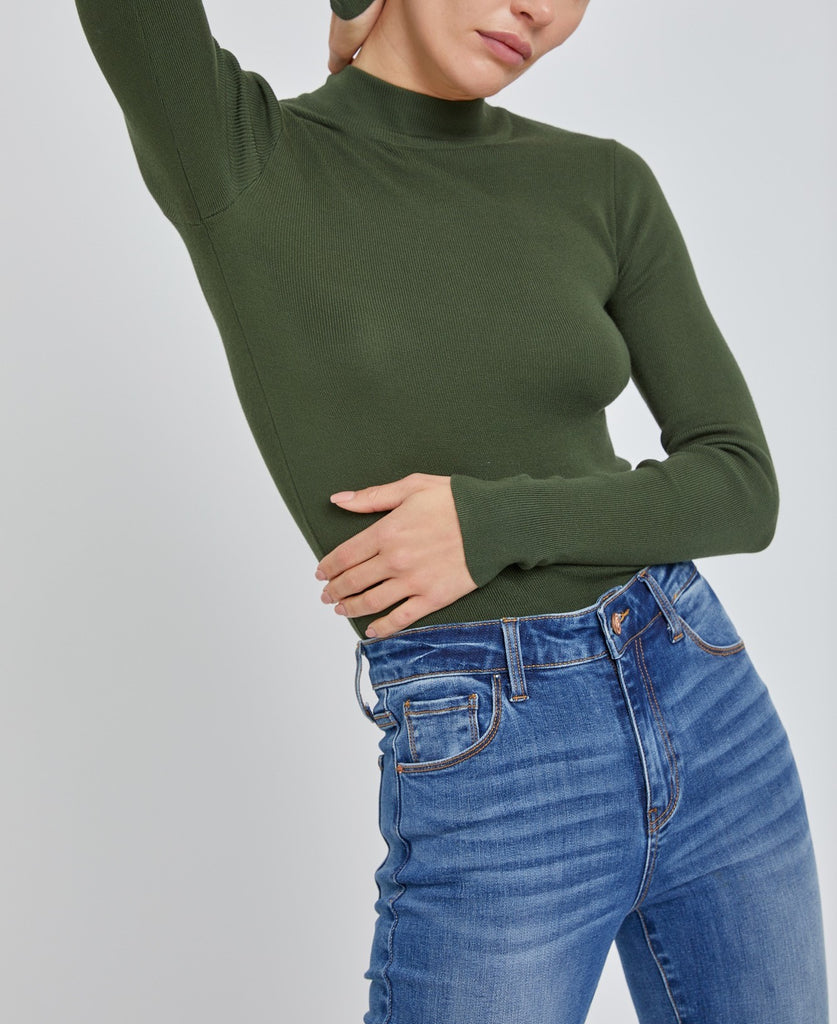 Moonbeam Long Sleeve Sweater Hunter. This ribbed long sleeve sweater features a mock neckline and fitted design making it the perfect layering piece for everyday.