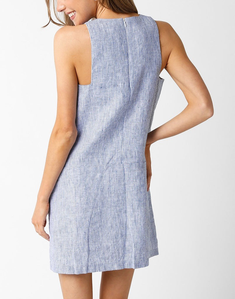 Yvette Sleeveless Linen Dress Blue Denim. This linen mini dress features a sleeveless design with a subtle stripe fabric and front pockets for a cute and casual everyday look perfect for spring or summer.