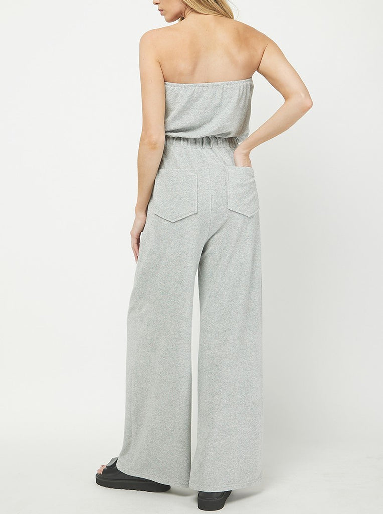 Nelly Sleeveless Terry Jumpsuit Heather Grey. This sleeveless terry jumpsuit features an elastic tie waist and faux button detail down the front, the perfect easy piece to throw on for a quick cute look.