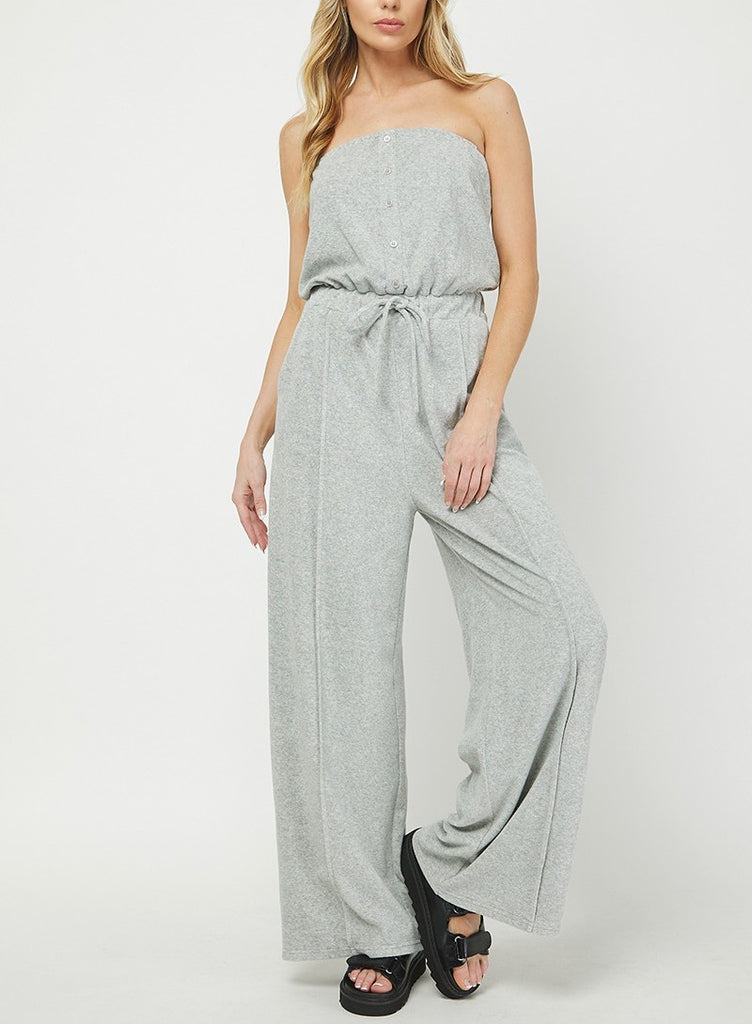 Nelly Sleeveless Terry Jumpsuit Heather Grey. This sleeveless terry jumpsuit features an elastic tie waist and faux button detail down the front, the perfect easy piece to throw on for a quick cute look.