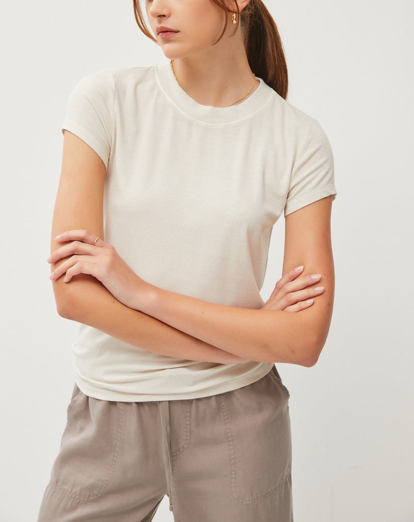 Rowan Classic Rib Crewneck Tee Ecru. This crewneck tee features a fitted silhouette in a soft rib fabric, a must have basic to add to your closet that goes effortlessly with any look.
