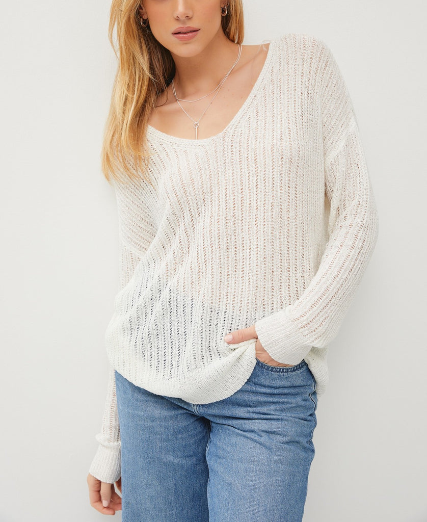 Teagan Sheer Knit Top White. This lightweight knit top features a wide v-neckline and long sleeves, perfect for layering over your fav tank and pairing with jeans.