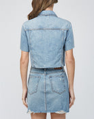 Hidden Short Sleeve Crop Jacket. This denim jacket features a cropped fit and short sleeve design with button closures and front patch pockets, wear it open as a layering piece or closed on its own.