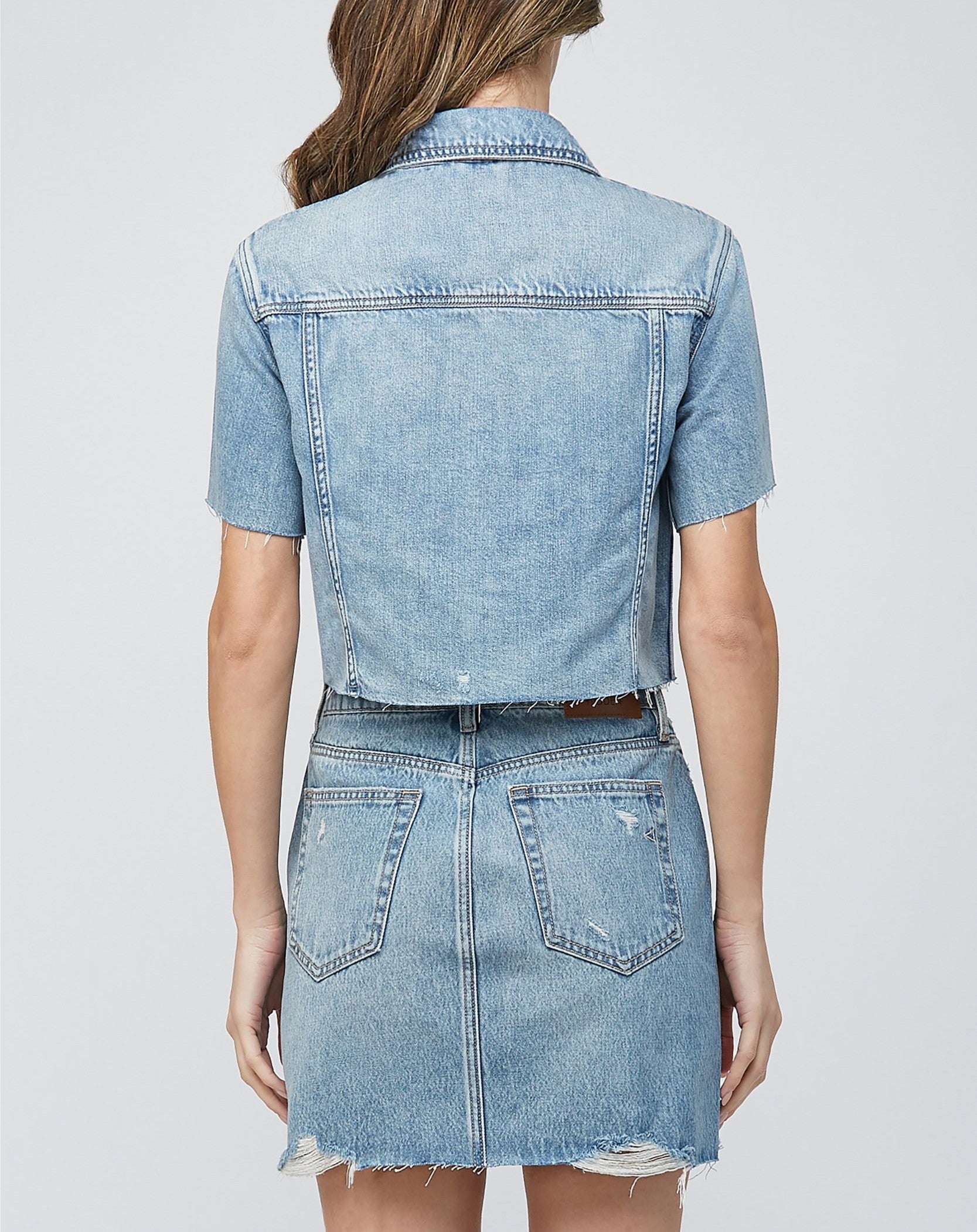 Hidden Short Sleeve Crop Jacket. This denim jacket features a cropped fit and short sleeve design with button closures and front patch pockets, wear it open as a layering piece or closed on its own.