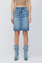 Hidden Midi Pencil Skirt Denim. This pencil skirt features a high waist with a midi length and medium blue wash with raw edge, the perfect piece to add to your spring rotation.