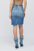 Hidden Midi Pencil Skirt Denim. This pencil skirt features a high waist with a midi length and medium blue wash with raw edge, the perfect piece to add to your spring rotation.