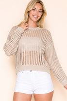 Open knit sweater with relaxed fit and breathable design styled over a tank with shorts