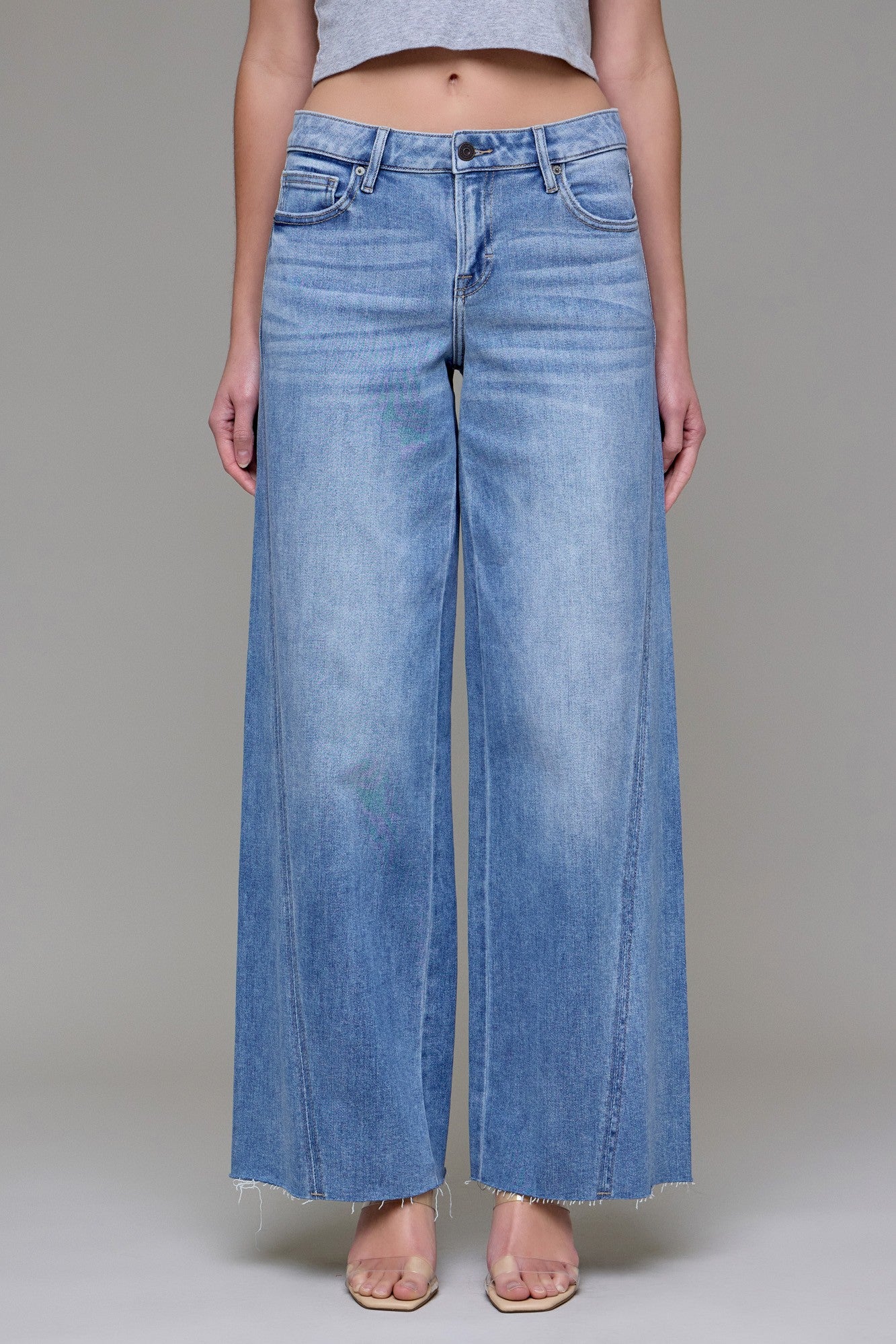 Wide-leg jeans with mid-rise fit and subtle fading styled with sandals