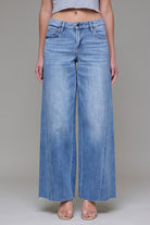 Wide-leg jeans with mid-rise fit and subtle fading styled with sandals