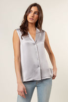 grey sleeveless button up collared blouse