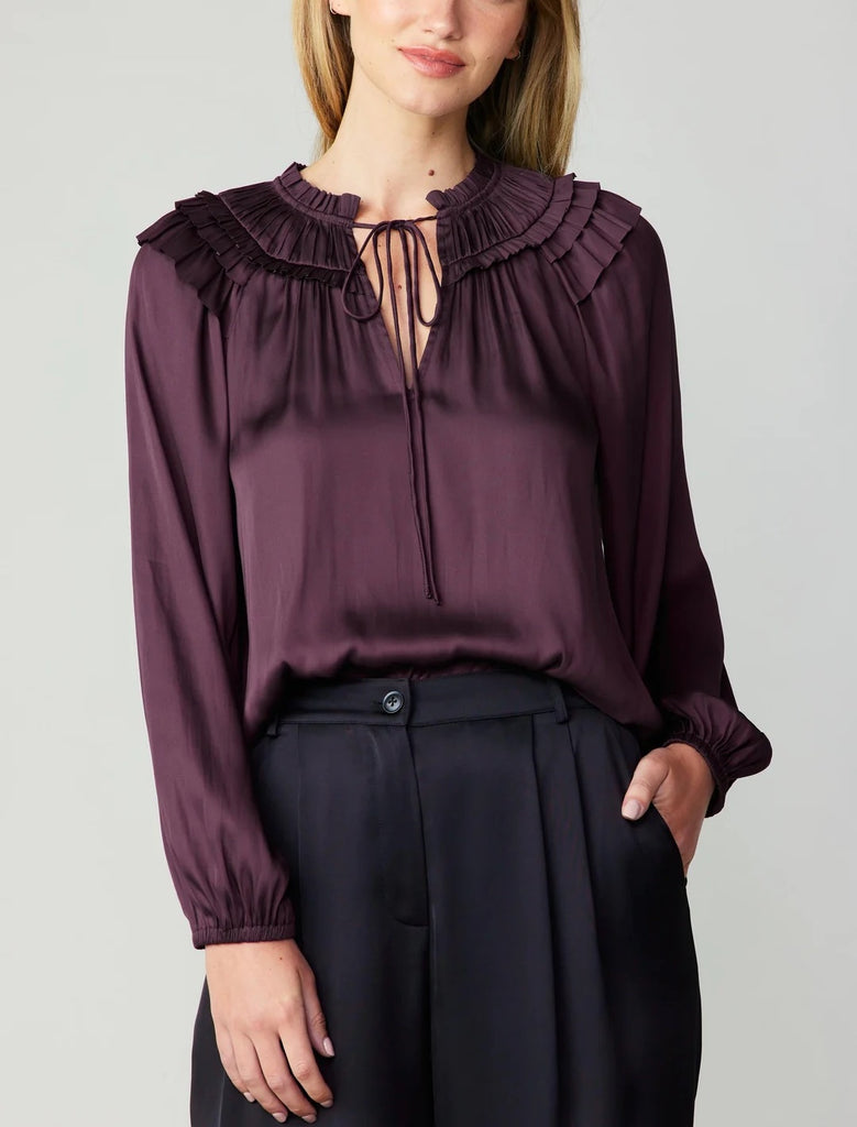 Current Air Smocked Shoulder Blouse Midnight Plum. A gathered yoke and layered ruffles at the shoulders heighten the feminine charm of this breezy blouse. It's cut for a loose, relaxed silhouette and features a split neckline, self-tie detailing, and long sleeves with elasticized cuffs.