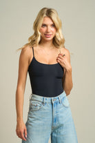Seamless spaghetti strap bodysuit with a fitted silhouette styled with denim jeans