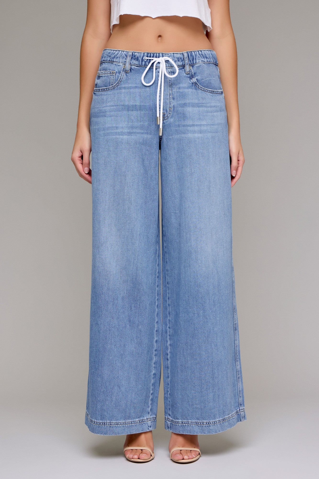 Wide-leg pull-on denim jeans with a drawstring waistband, relaxed fit, and full-length silhouette.
