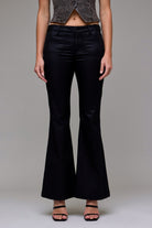 black coated jeans, coated flare jeans, leather look jeans, shiny black denim, women’s coated pants, low rise coated jeans, sleek black jeans, night out denim, coated stretch jeans, dressy black jeans, leather effect jeans, chic coated flare pants