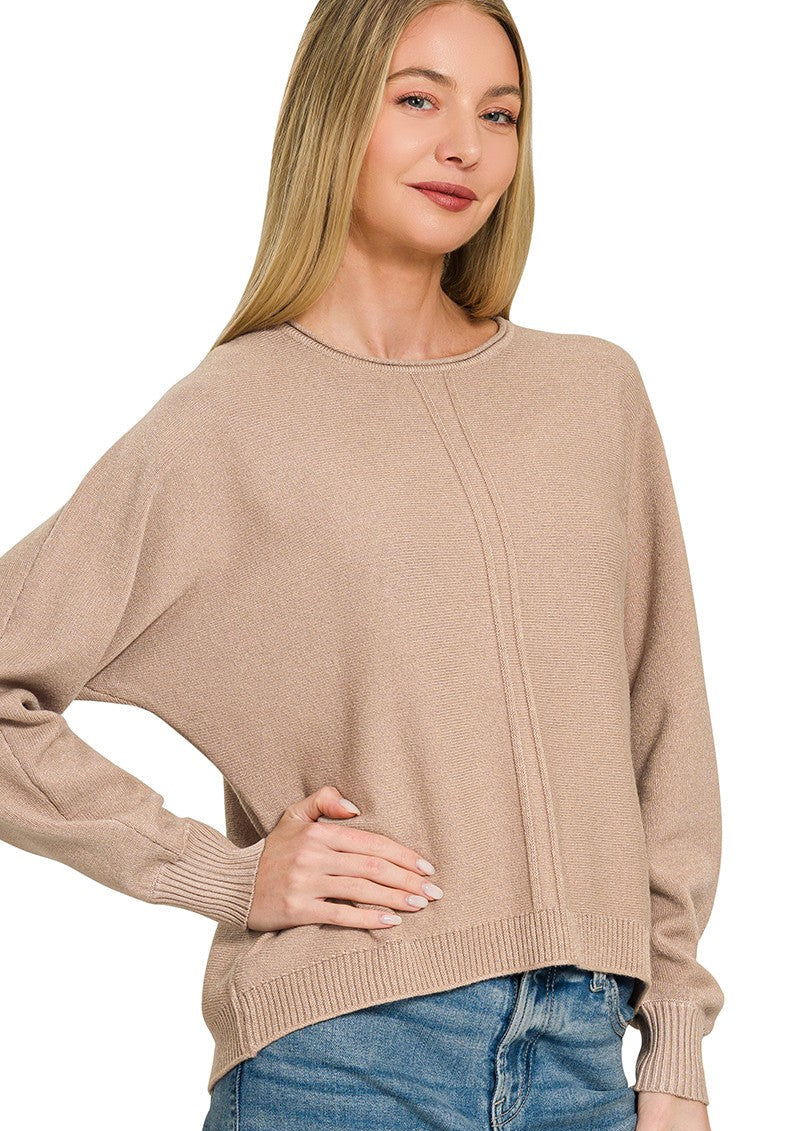 Model wearing a relaxed-fit lightweight knit sweater with drop shoulders, exposed center seam detailing, ribbed cuffs, and a ribbed hem paired with blue denim.