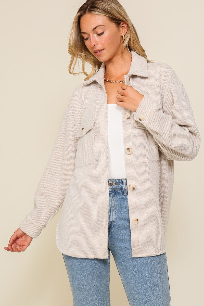 Oversized textured button-front shirt jacket with collar, chest pockets, and long sleeves.