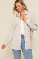 Oversized textured button-front shirt jacket with collar, chest pockets, and long sleeves.
