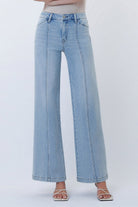 High-rise wide leg jeans with front seam detailing and a structured fit styled with sandals