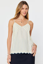 woman wearing a striped camisole tank with thin straps and scalloped hem detail styled with a midi skirt