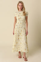Floral midi dress with smocked bodice, puff sleeves, and flowy skirt styled with sandals