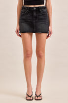 High-rise denim mini skirt with five-pocket styling and raw hem.