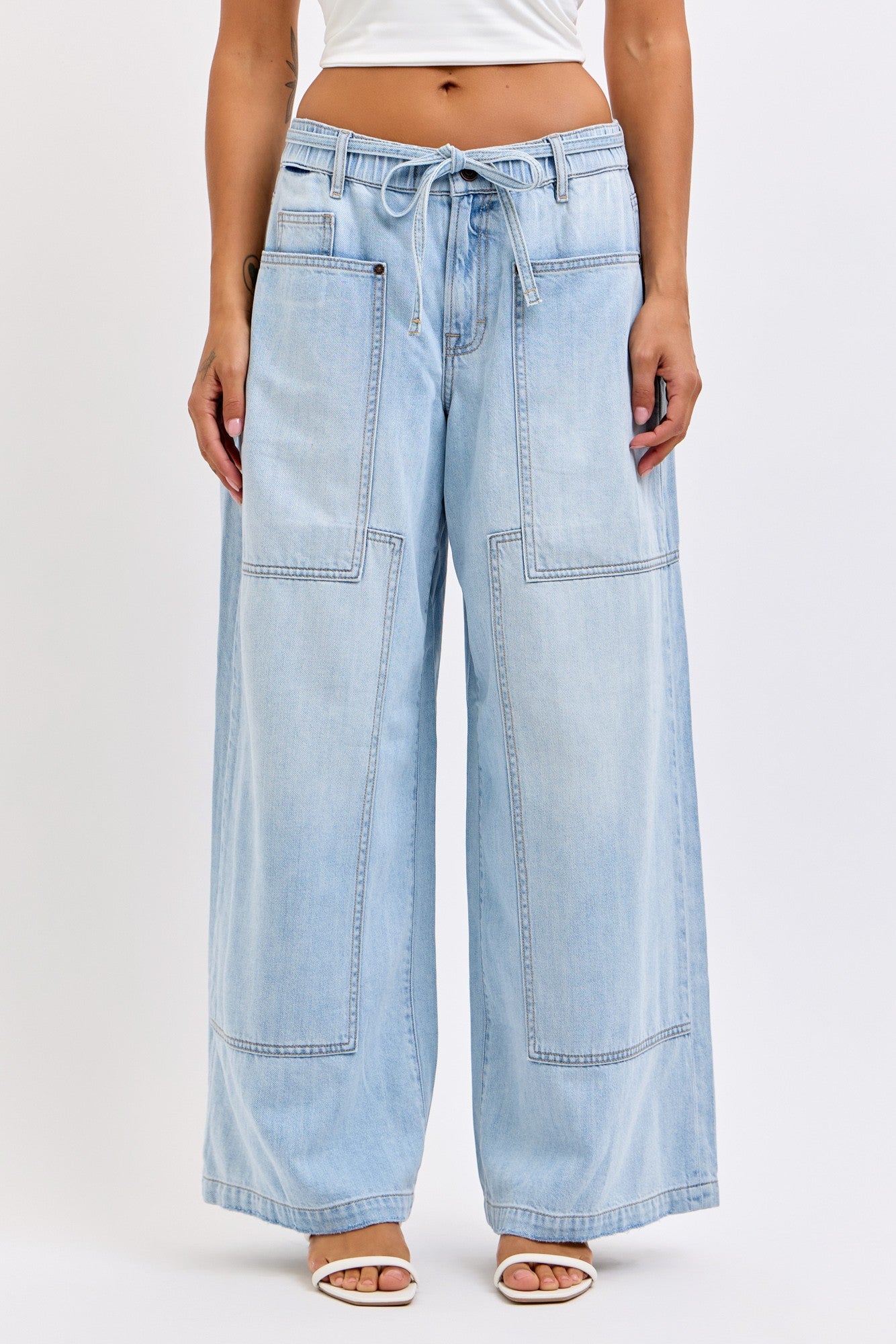 Model wearing wide-leg jeans with oversized patch pockets and a removable tie belt.