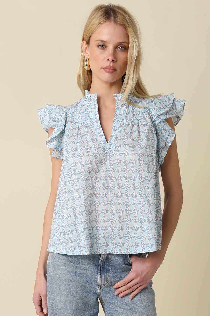 Relaxed blouse with ruffle sleeves and split neckline in floral print, styled with denim.