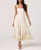Woman wearing a floral midi dress with lace trim straps, a fitted bodice, and a flowy skirt with a soft floral print