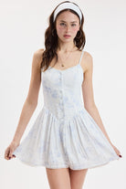 Button-front mini dress with thin straps, fitted bodice, and flared skirt with delicate trim details