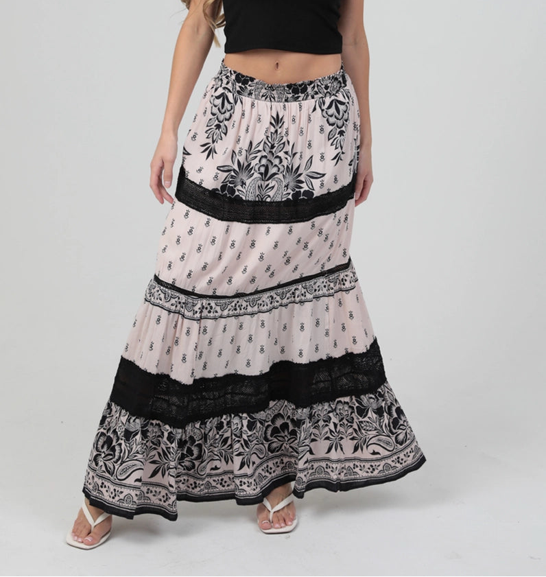 Tiered maxi skirt with mixed print design and lace trim detailing, styled with a cropped tank top.