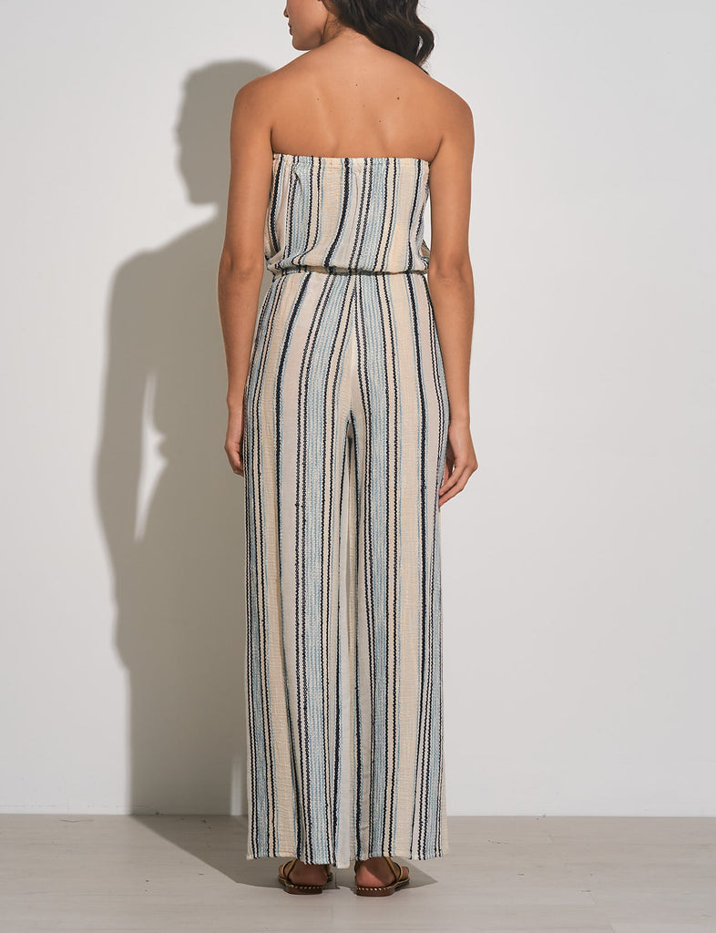 Elan Strapless Stripe Jumpsuit Natural Blue Stripe. This stripe jumpsuit features a strapless design with a tie waist making it so easy to throw on with a denim jacket and sandals for a quick go to outfit.