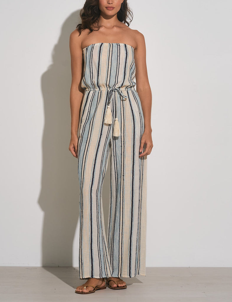 Elan Strapless Stripe Jumpsuit Natural Blue Stripe. This stripe jumpsuit features a strapless design with a tie waist making it so easy to throw on with a denim jacket and sandals for a quick go to outfit.