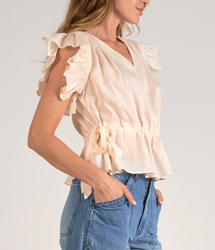 Elan Ruffle Sleeve V-Neck Top Beige. This pretty top features a v-neck design with ruffle sleeves and side tie details, perfect for day or night, it goes effortlessly with any jeans or pants.