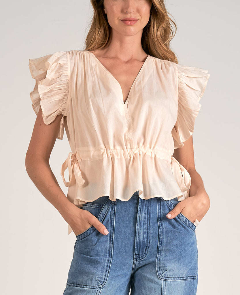 Elan Ruffle Sleeve V-Neck Top Beige. This pretty top features a v-neck design with ruffle sleeves and side tie details, perfect for day or night, it goes effortlessly with any jeans or pants.