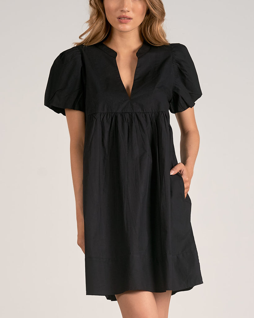 Elan V-Neck Mini Dress Black. This adorable short sleeve dress features a baby doll fit with a v-neckline, so easy to dress up or down with a pair or heels or your fav sneakers and denim jacket.