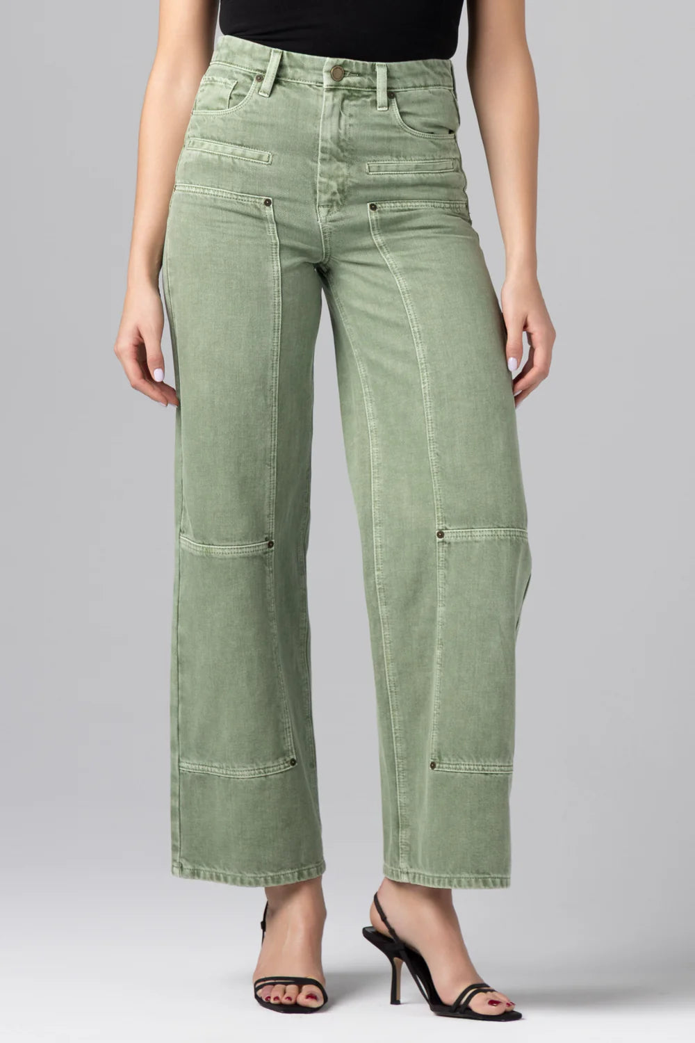 Woman wearing high rise utility straight leg jeans with seam detailing paired with a strapless top and heels