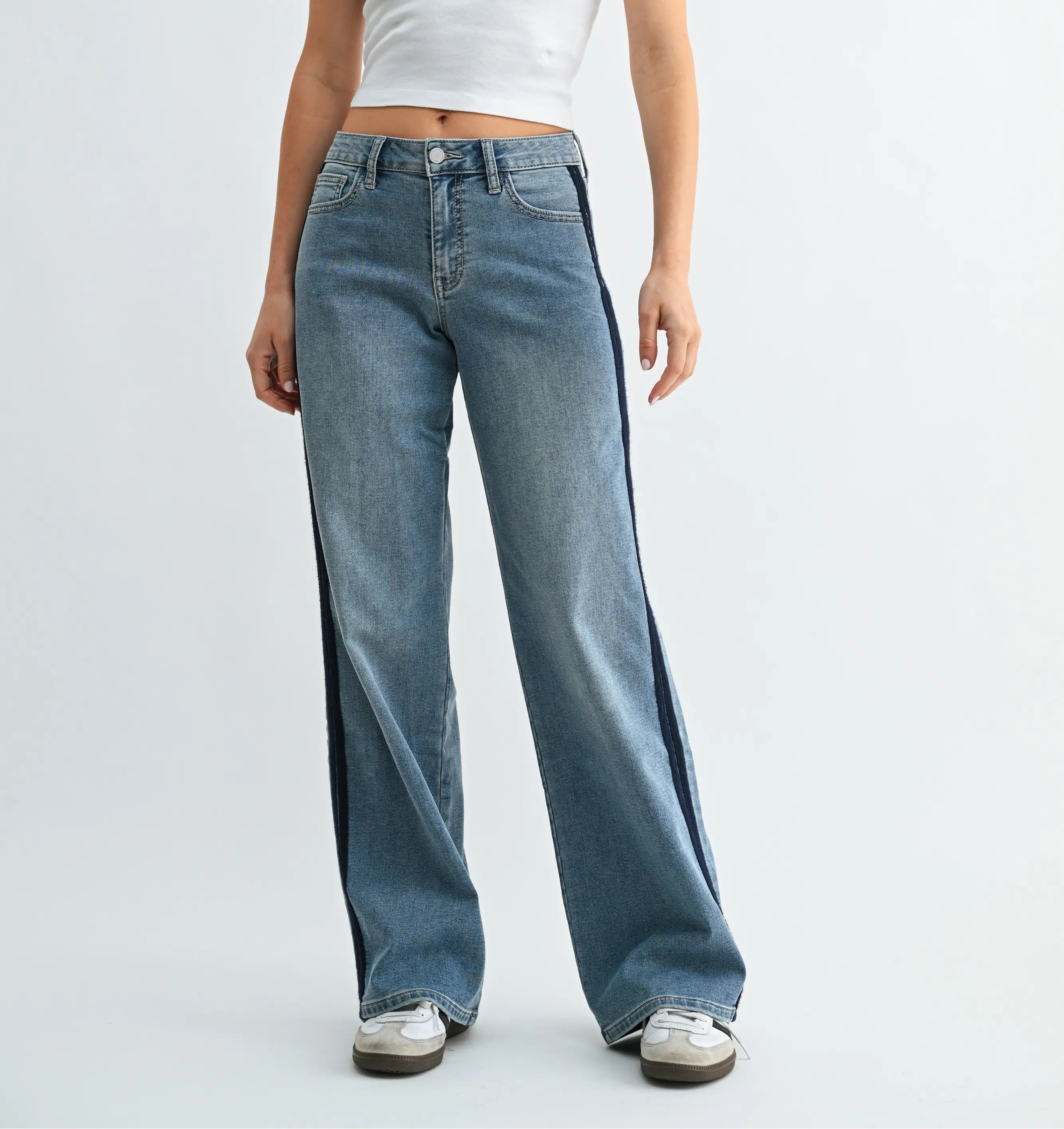 Woman wearing relaxed wide-leg jeans with contrast stripes along the outer seams.