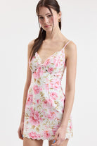 Women's floral print mini dress with spaghetti straps, bow-front detail, fitted silhouette, and scalloped hem.