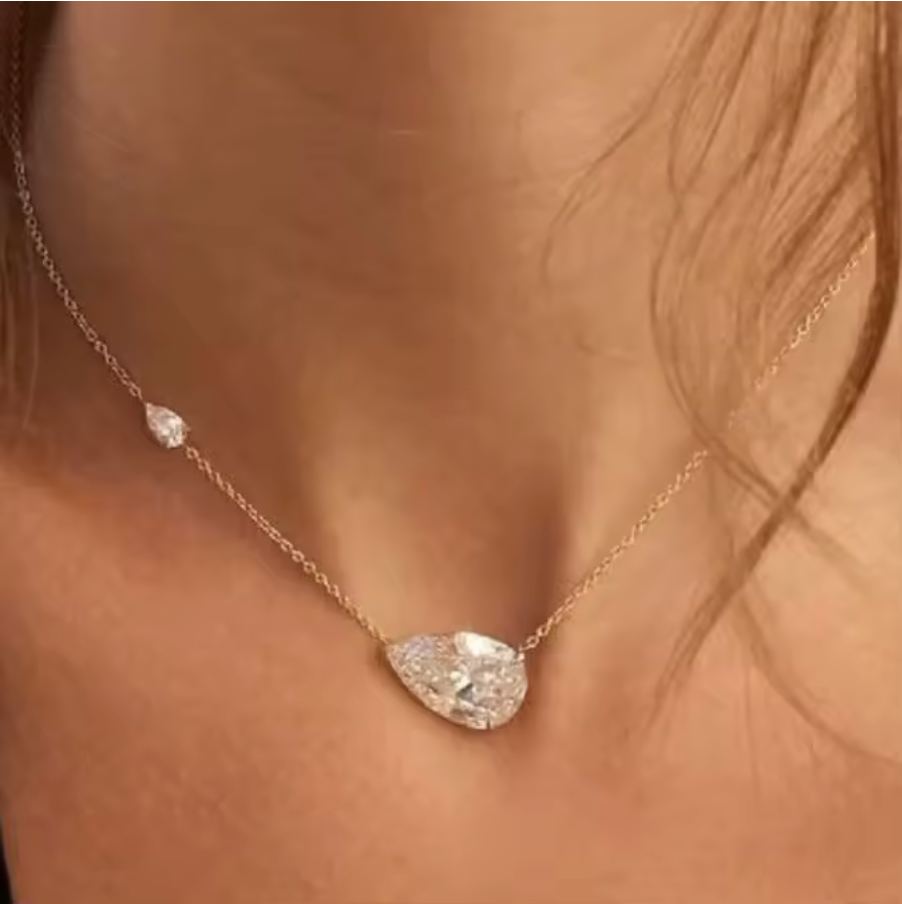 Dainty necklace with a marquise-cut crystal centerpiece and a single bezel-set accent on a fine chain.