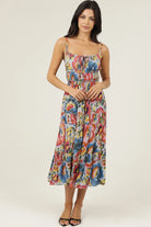 Printed midi dress with thin straps, smocked bodice, and tiered skirt styled with sandals