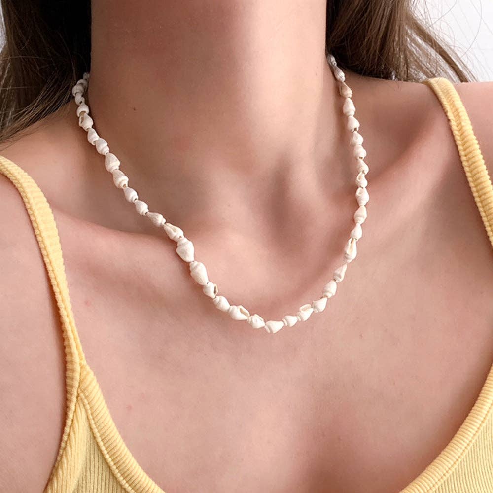 Natural shell bead necklace featuring organic shell beads strung along a classic strand for a coastal-inspired look.
