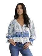 Women's floral print blouse with crochet lace detailing, long puff sleeves, tie-front neckline, and a relaxed bohemian silhouette.