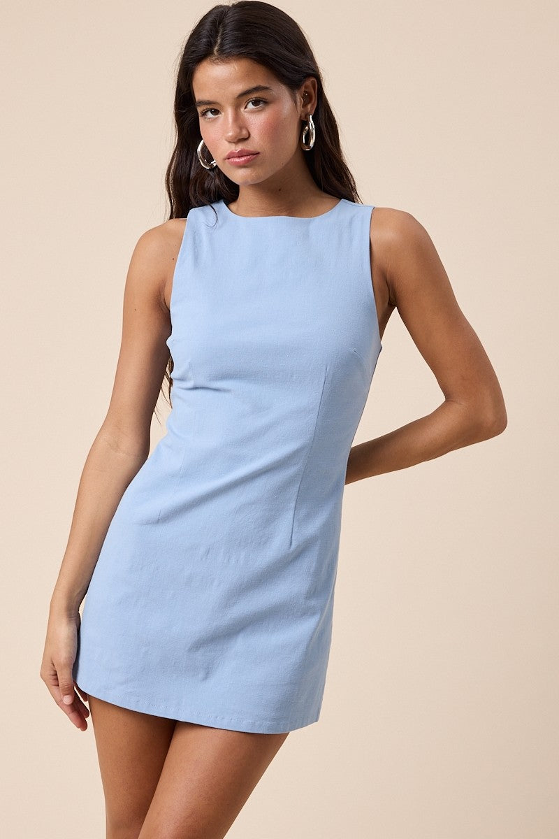Sleeveless mini dress with high neckline and fitted silhouette styled with hoop earrings