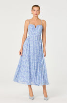 Woman wearing a pleated midi dress with delicate straps and a flowy silhouette designed for an elegant look