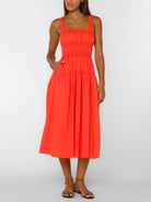 Bright midi dress with smocked bodice, tiered skirt, and ruffle straps shown from the back with strappy