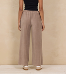 Woman wearing a wide-leg pant with an elastic waist and side pockets.