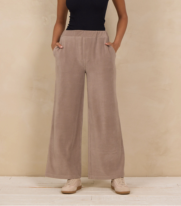 Woman wearing a wide-leg pant with an elastic waist and side pockets.