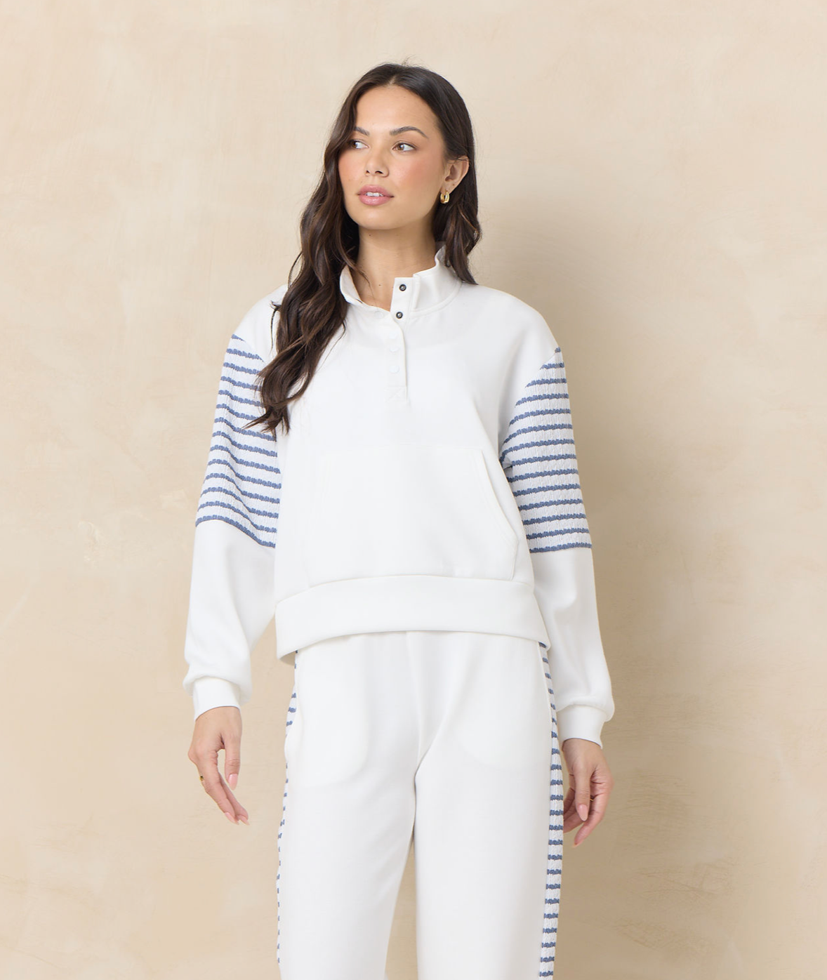 Matching ivory lounge set with striped sleeve and pant detailing featuring a relaxed pullover top and coordinating wide leg pants.