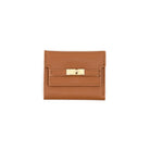 A small tan leather wallet with a gold turn-lock clasp, photographed flat against a solid white background.