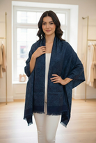 Woman wearing a paisley-print wrap with fringed trim.